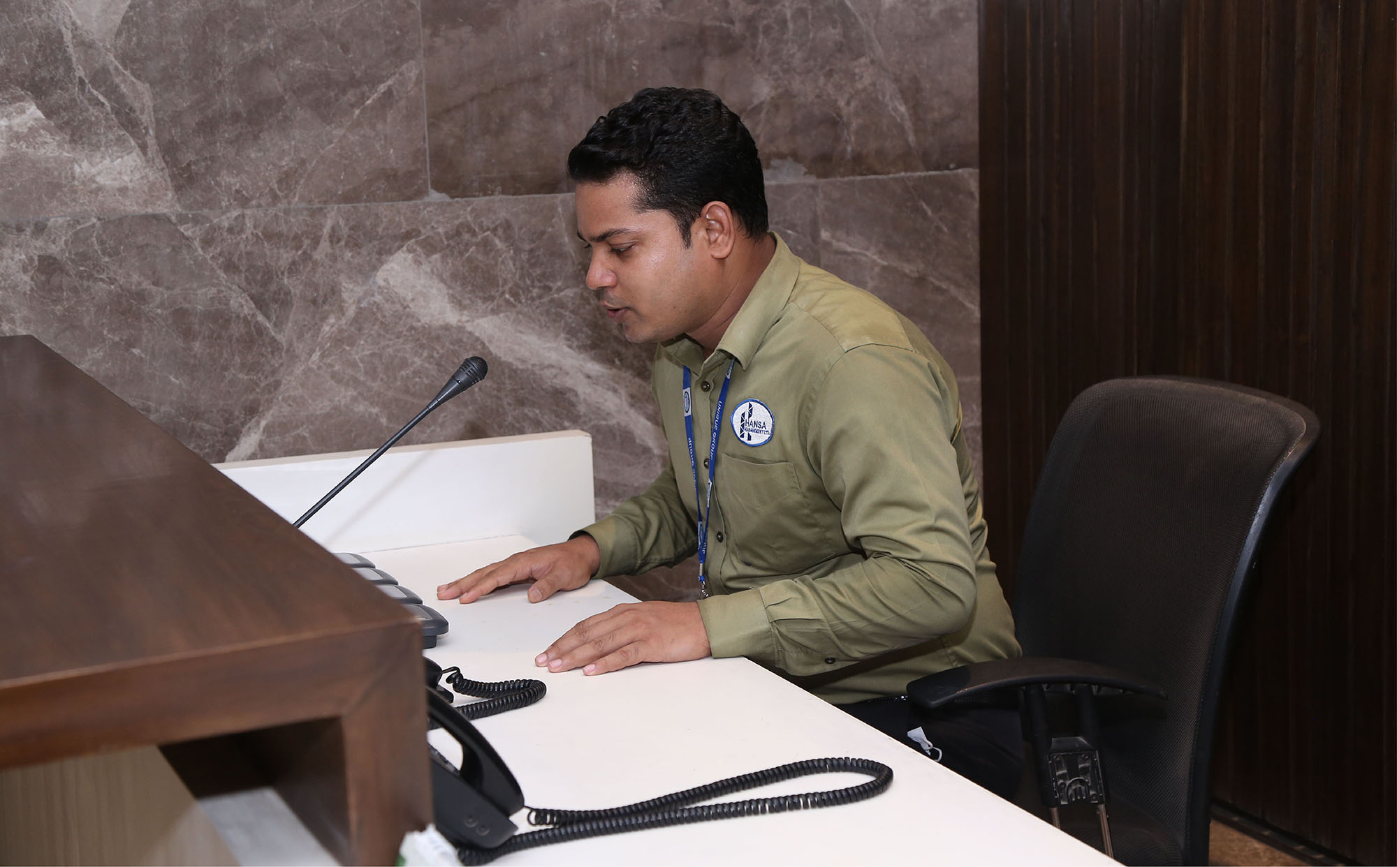 HANSA front office executive at a reception desk with telephone and microphone